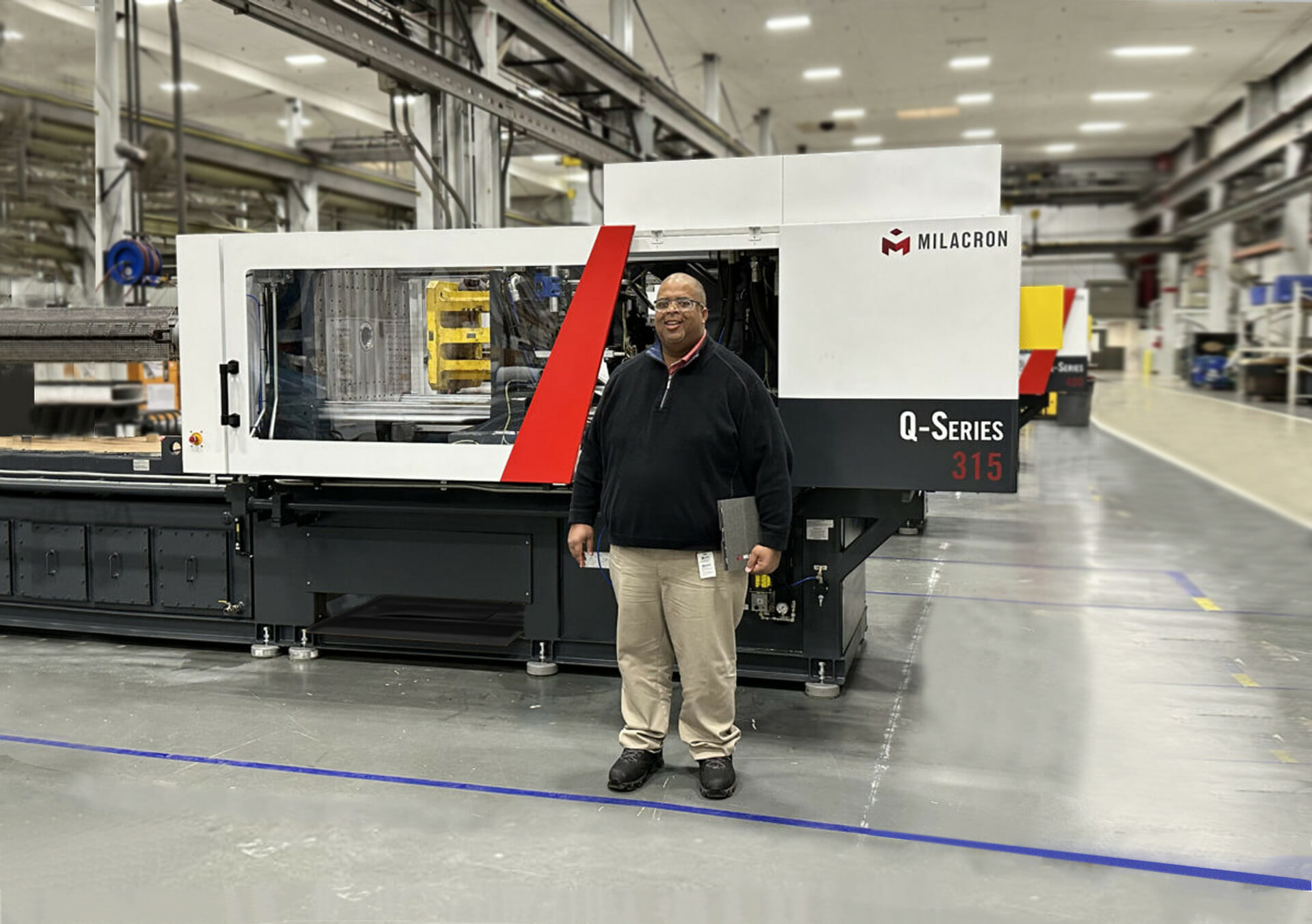 team member in factory by large machine