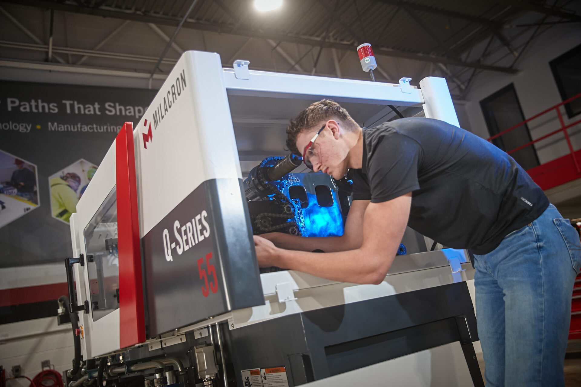 Man servicing Milacron machine